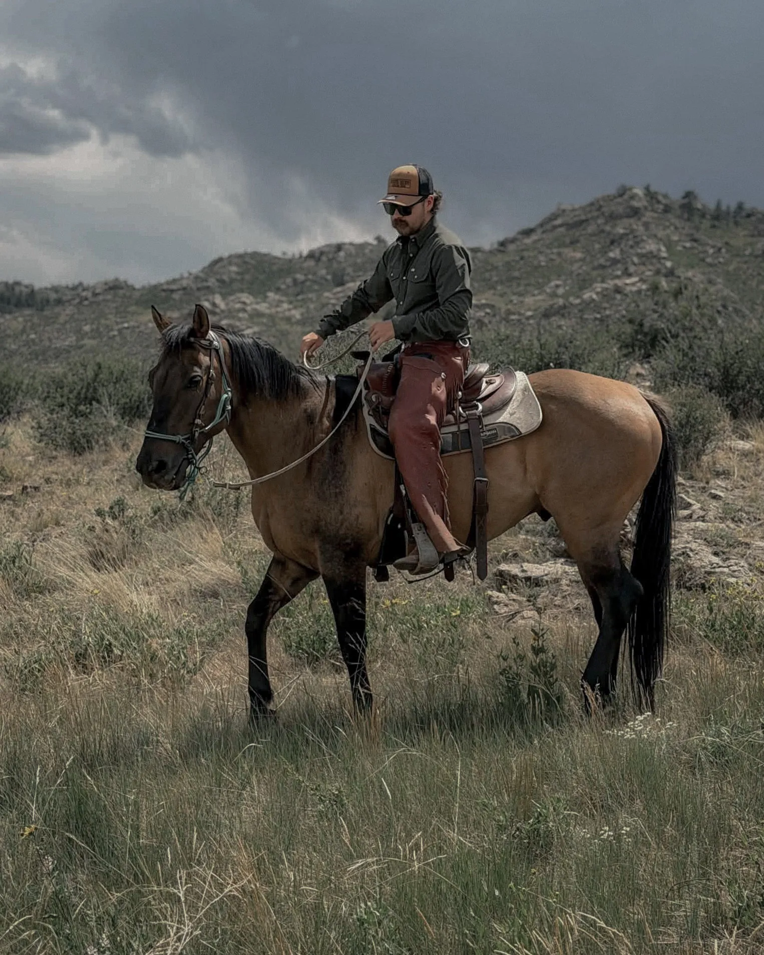 Anthony riding a young horse through Wyoming grassland