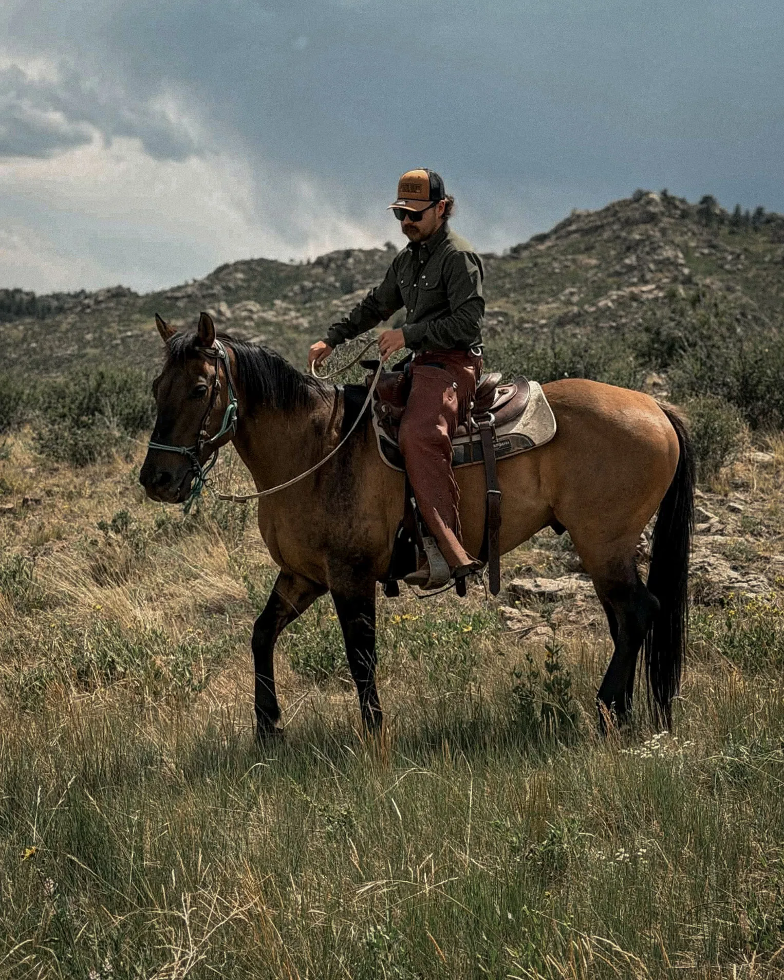Anthony riding a young horse through Wyoming grassland